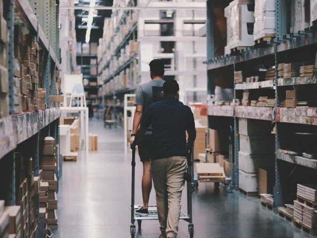 Warehouse with two workers moving a cart